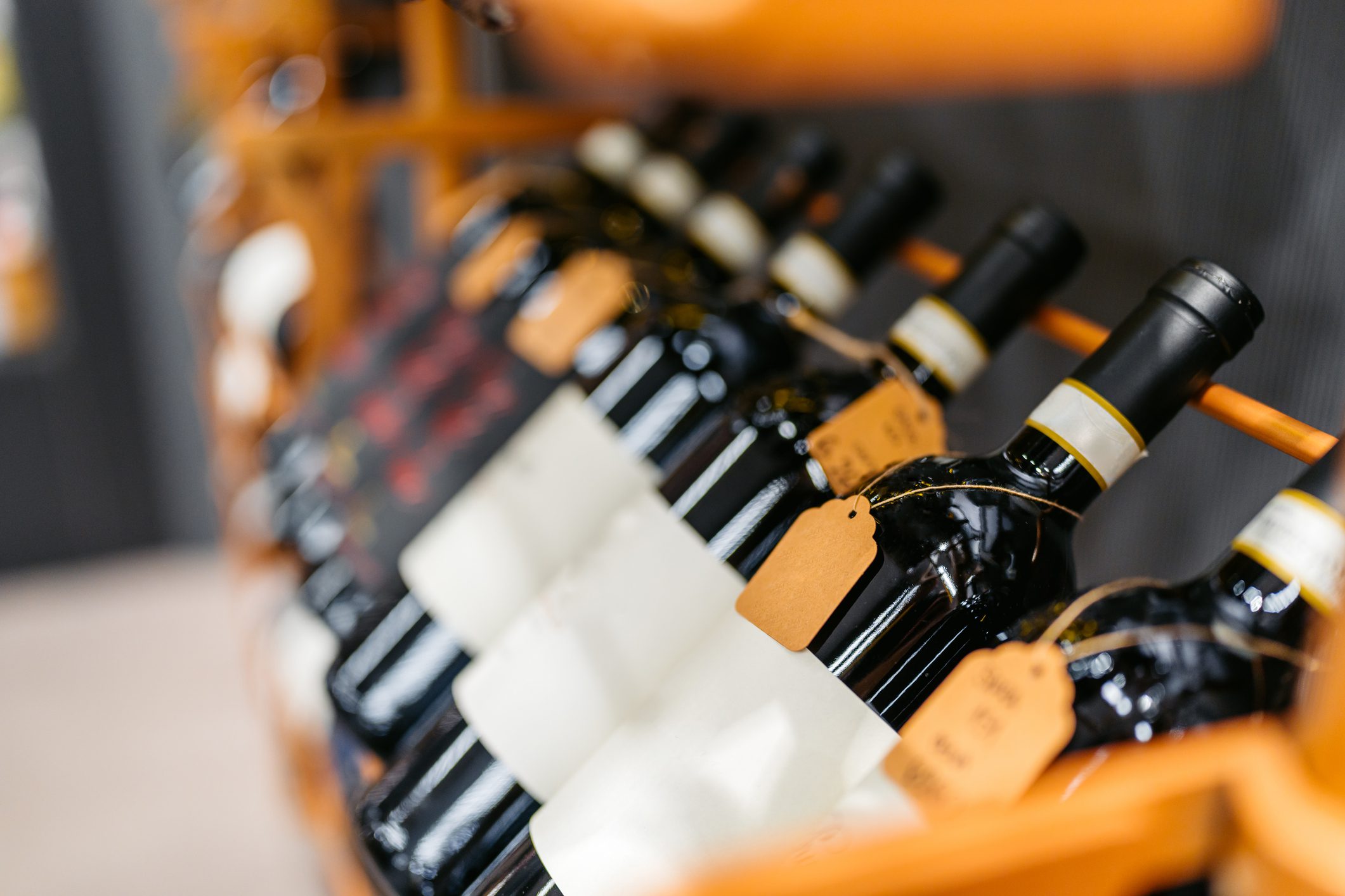 Rows of wine bottles neatly arranged on a wooden rack.
